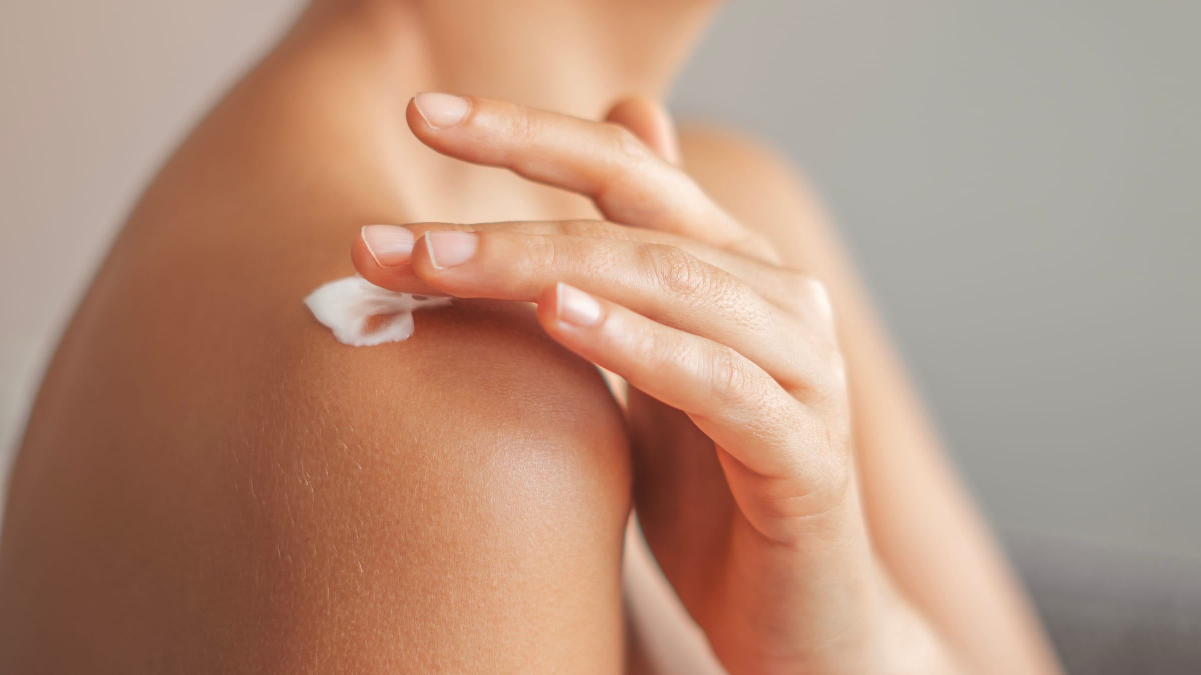 Woman smoothing moisturising cream onto her forearm