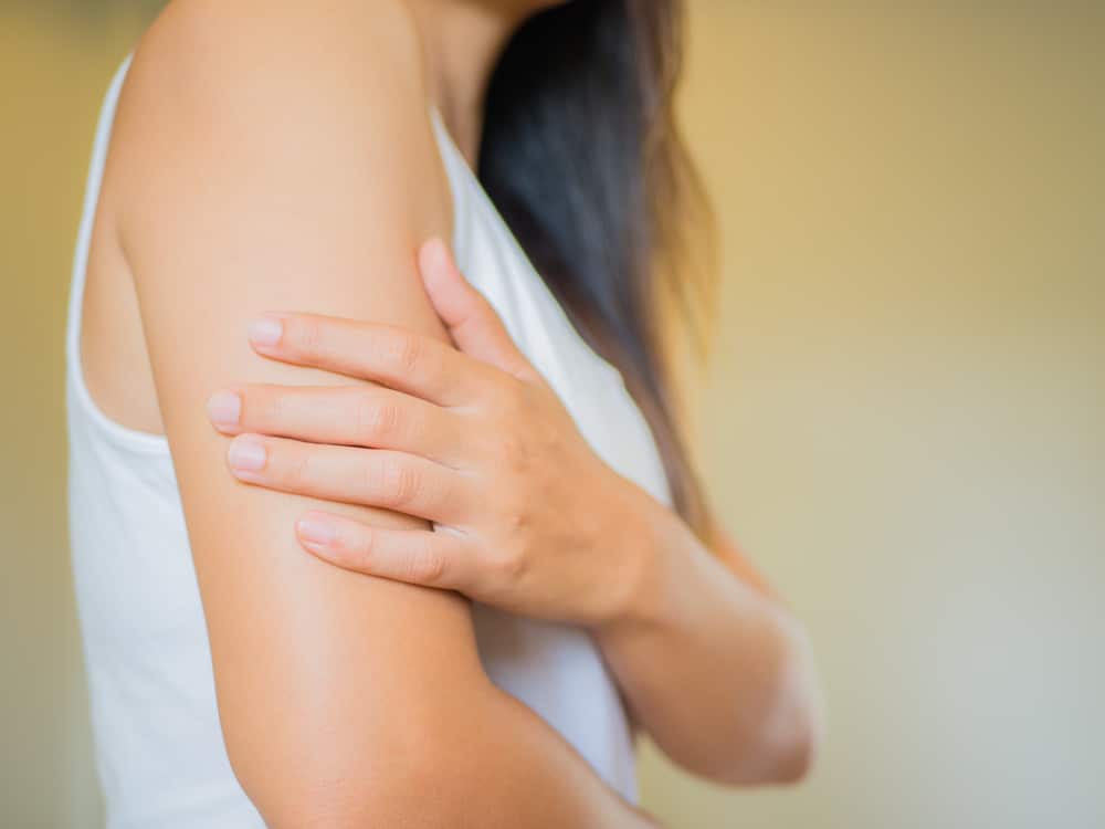 Woman holding her upper arm