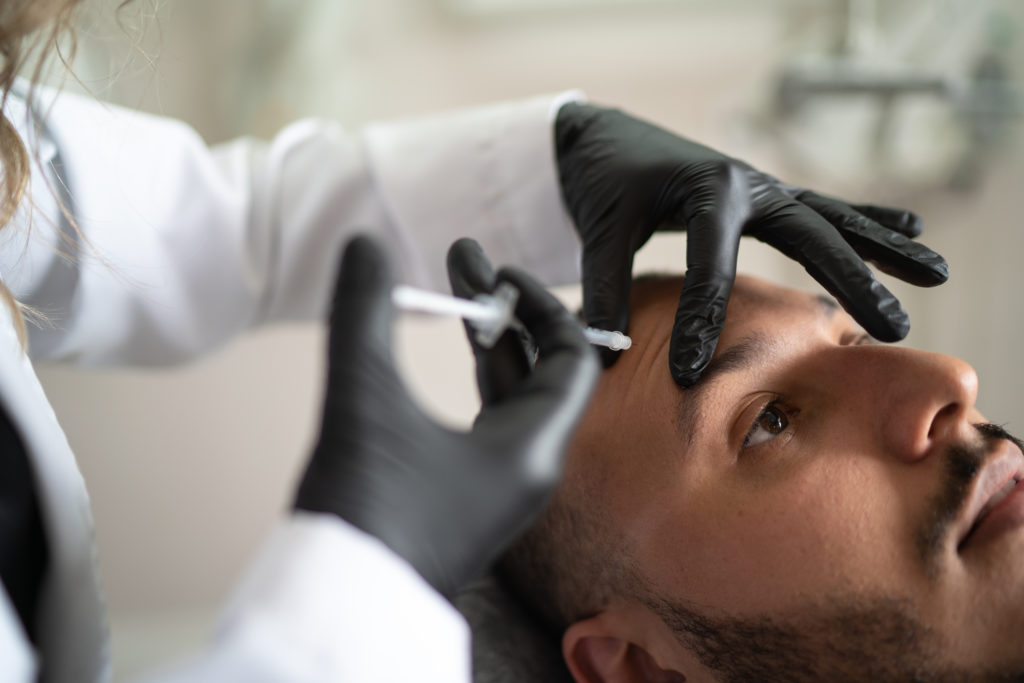 man getting botox injections in the forehead