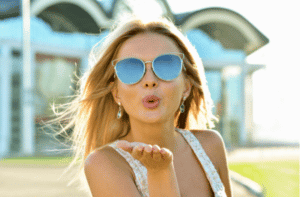 Outdoor fashion portrait of young pretty blond woman in sunny day on street.