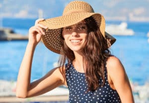 lovely girl in a hat protects her face from the sun