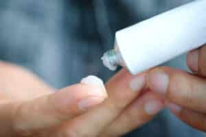 Close up of woman’s hands with tube of lotion for psoriasis treatment in LA